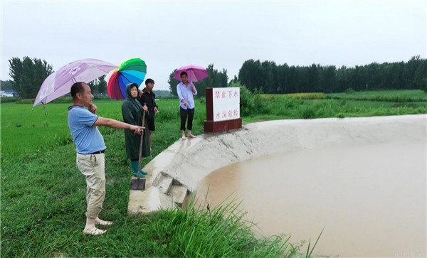 常立军（左一）冒雨排查水库堰塘安全隐患.jpg