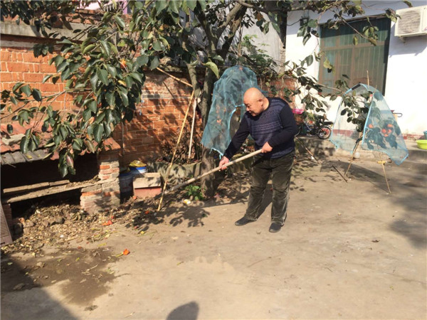 图一：岳宏伟帮助贫困户打扫卫生。.jpg